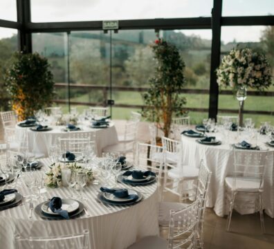 Beautifully arranged wedding reception tables with floral decor and a scenic outdoor view.